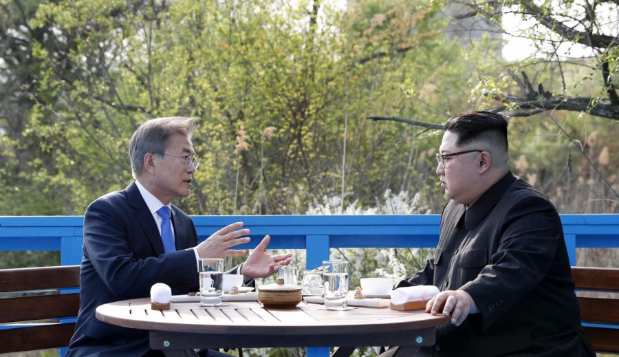 President Moon Jae-in and Chairman of the State Affairs Commission Kim Jong Un share conversations while they take a walk on the Footbridge, where there is a sign for the Military Demarcation Line (MDL) in Panmunjeom on April 27.