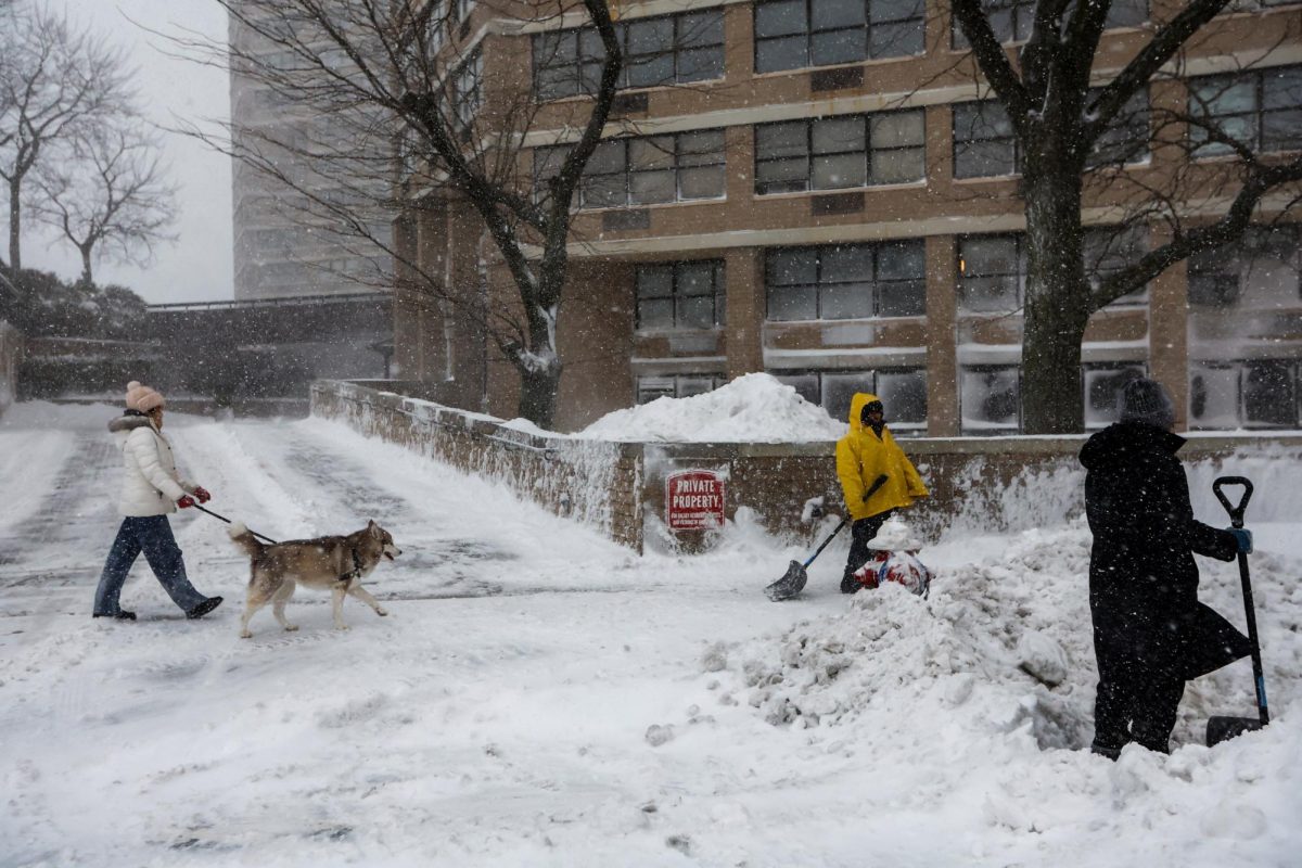 People clean the sidewalk and street of the snow during a winter storm in Guttenberg, New Jersey, U.S., February 23, 2026. REUTERS/Eduardo Munoz